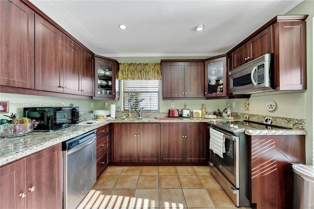 8914 SW 5th Ln, Miami, FL 33174 - kitchen featuring light tile patterned flooring, light stone counters, a sink, glass insert cabinets, and stainless steel appliances
