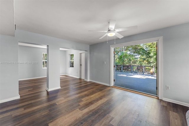 empty room featuring baseboards, wood finished floors, and a ceiling fan