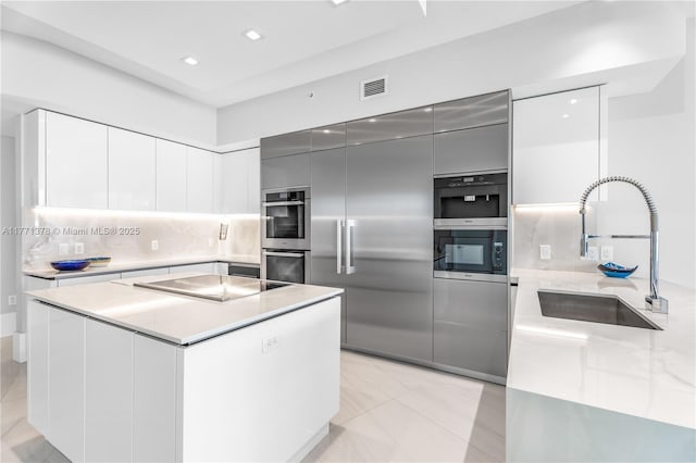 5000 Island Estates Dr Unit 704, Aventura, FL 33160 - kitchen with black electric stovetop, double oven, a sink, visible vents, and modern cabinets