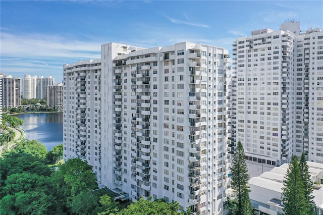 view of building exterior featuring a water view and a view of city