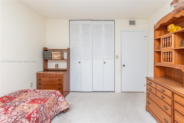 bedroom with light carpet, visible vents, and a closet