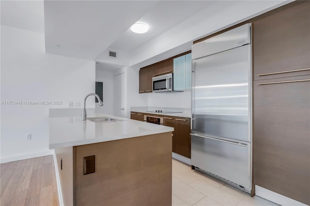 55 SE 6th St Unit 3503, Miami, FL 33131 - kitchen featuring stainless steel appliances, a sink, light countertops, dark brown cabinets, and modern cabinets