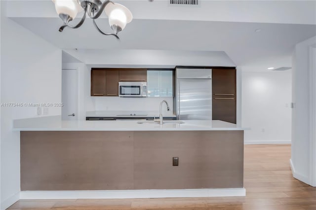 55 SE 6th St Unit 3503, Miami, FL 33131 - kitchen featuring appliances with stainless steel finishes, a sink, light countertops, dark brown cabinetry, and recessed lighting