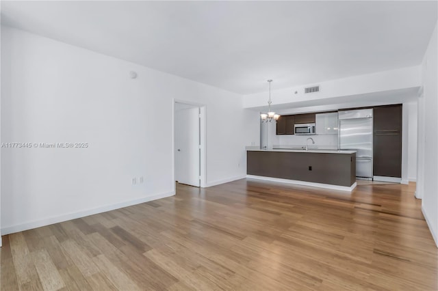 55 SE 6th St Unit 3503, Miami, FL 33131 - unfurnished living room featuring a chandelier, light wood finished floors, a sink, and baseboards