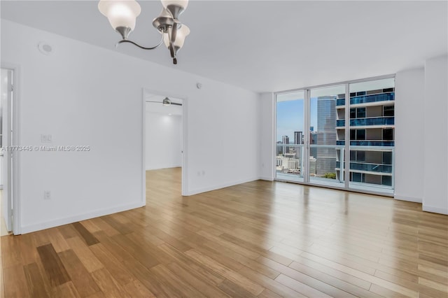 55 SE 6th St Unit 3503, Miami, FL 33131 - empty room with a chandelier, wood finished floors, floor to ceiling windows, and baseboards