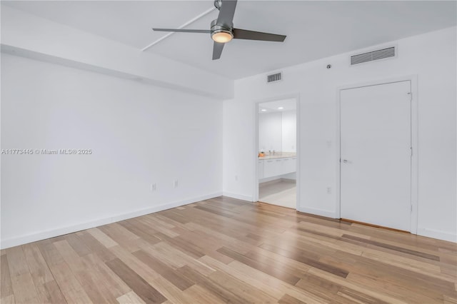 55 SE 6th St Unit 3503, Miami, FL 33131 - unfurnished bedroom with light wood-type flooring, connected bathroom, a ceiling fan, and baseboards