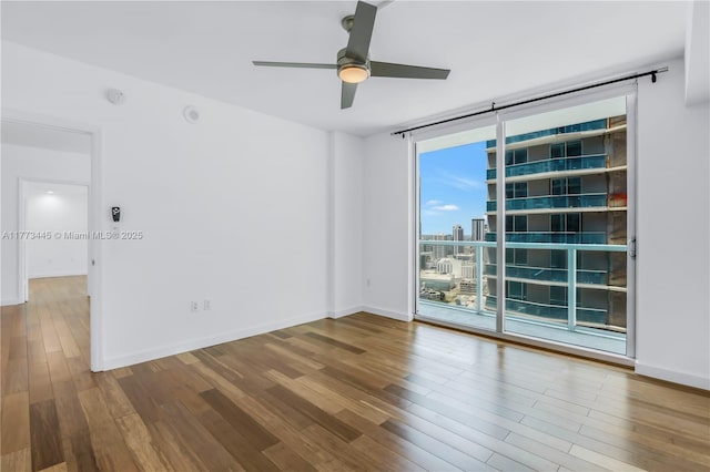 55 SE 6th St Unit 3503, Miami, FL 33131 - empty room featuring wood finished floors, a ceiling fan, expansive windows, and baseboards