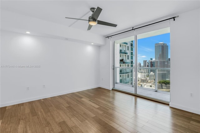 55 SE 6th St Unit 3503, Miami, FL 33131 - spare room with wood finished floors, a ceiling fan, a view of skyline, and baseboards