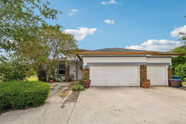 view of front of home featuring concrete driveway, stucco siding, and stone siding