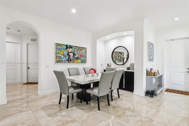 dining space featuring arched walkways, marble finish floor, visible vents, and recessed lighting