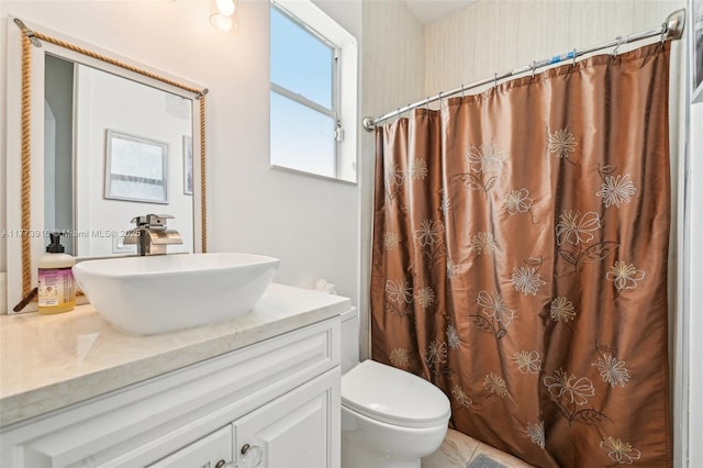 bathroom with toilet, vanity, and a shower with curtain