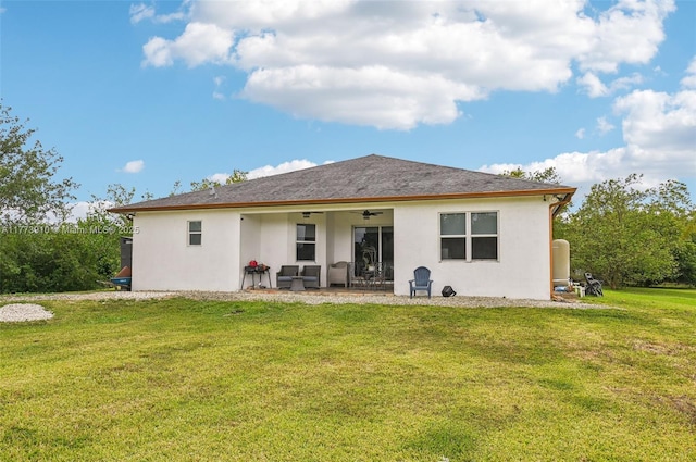back of house featuring a yard, a patio area, stucco siding, and a ceiling fan
