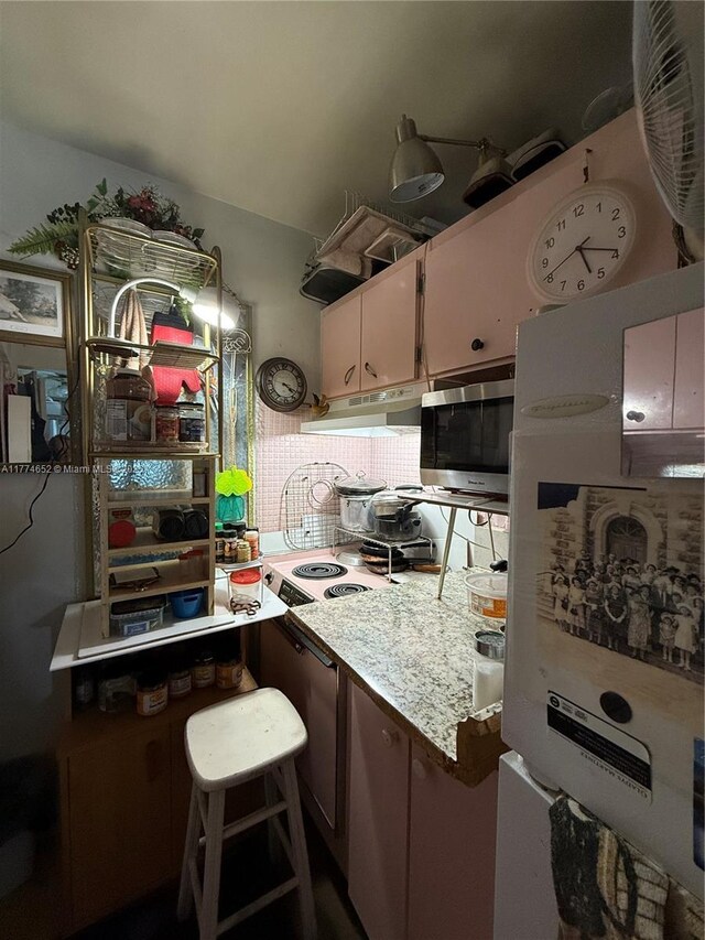 15610 NE 6th Ave Unit 32C, Miami, FL 33162 - kitchen with stainless steel microwave, white cabinetry, stovetop, light countertops, and under cabinet range hood