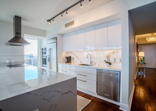 1850 S Ocean Dr Unit 1004, Hallandale Beach, FL 33009 - kitchen featuring wall chimney range hood, modern cabinets, dark wood-type flooring, a sink, and appliances with stainless steel finishes