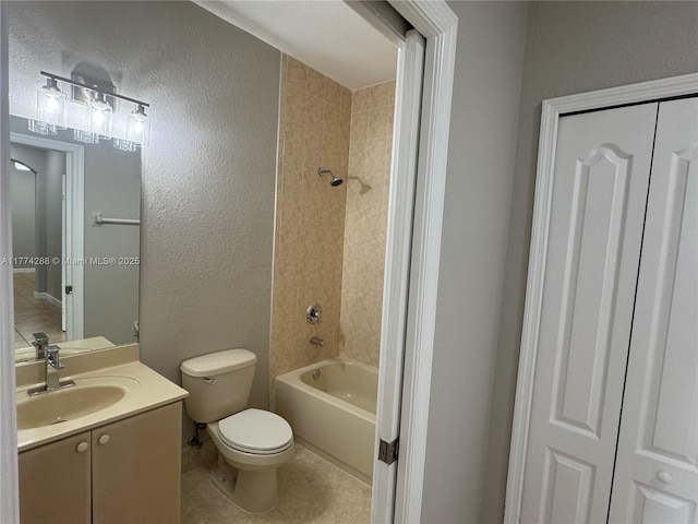 bathroom with toilet, vanity, shower / bathing tub combination, tile patterned flooring, and a textured wall
