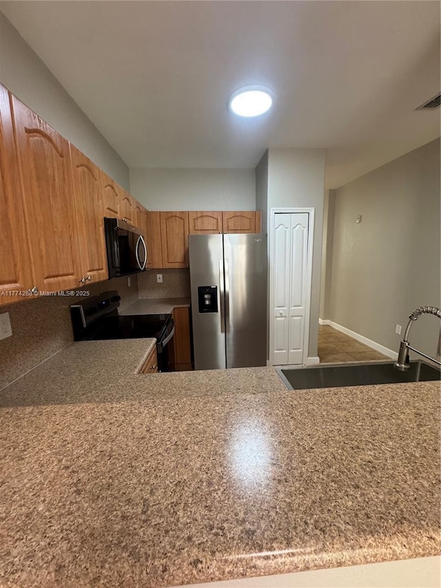 kitchen with baseboards, visible vents, a sink, and stainless steel appliances