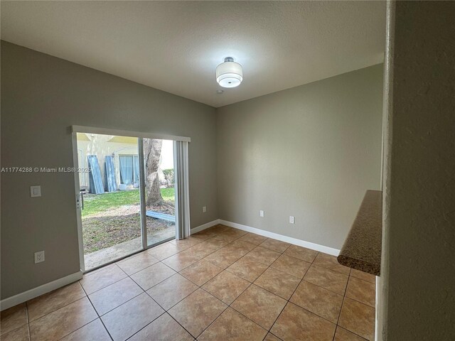 unfurnished room with baseboards and light tile patterned floors