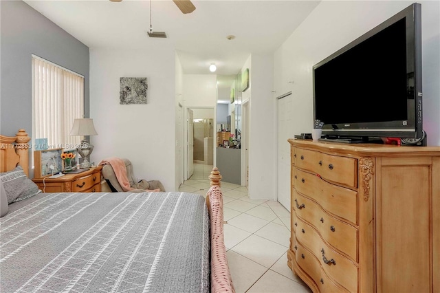 bedroom with light tile patterned floors, a ceiling fan, visible vents, and connected bathroom