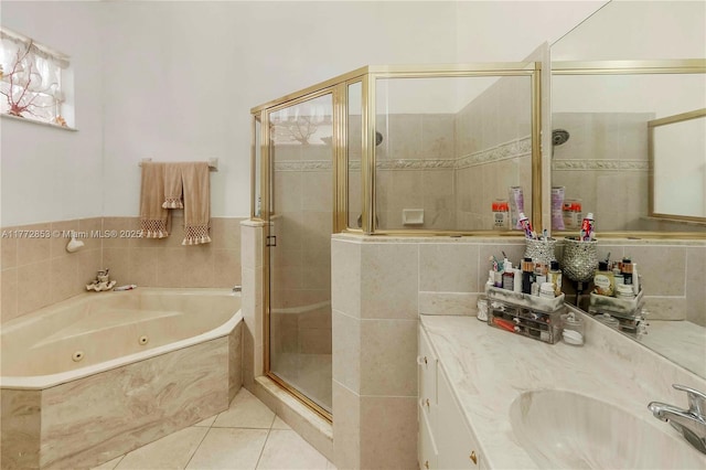 full bath featuring a whirlpool tub, vanity, tile patterned flooring, a shower stall, and tile walls