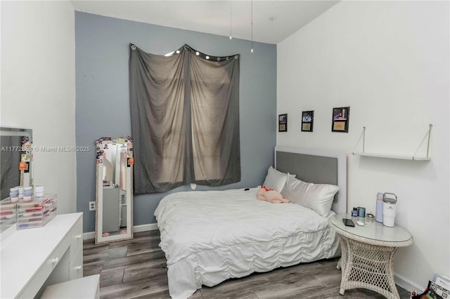 bedroom with baseboards and dark wood-style floors