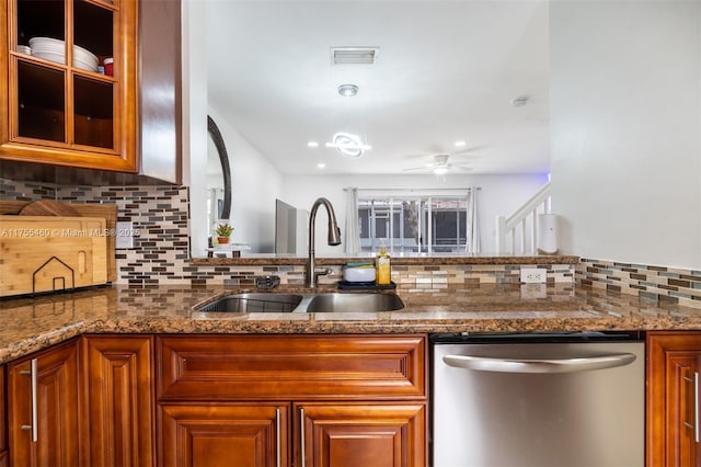 kitchen featuring backsplash, visible vents, brown cabinetry, dishwasher, and a sink