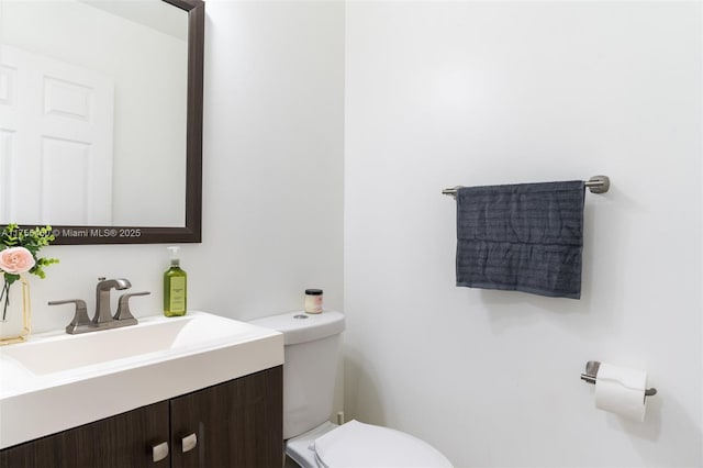 half bathroom with vanity and toilet
