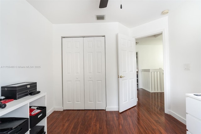 office with dark wood-type flooring, visible vents, baseboards, and a ceiling fan