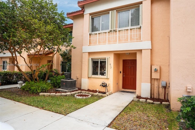 view of property featuring central air condition unit and stucco siding