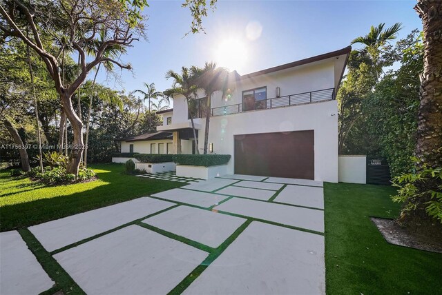 7360 SW 53rd Pl, Miami, FL 33143 - contemporary home with a balcony, an attached garage, a front lawn, and stucco siding