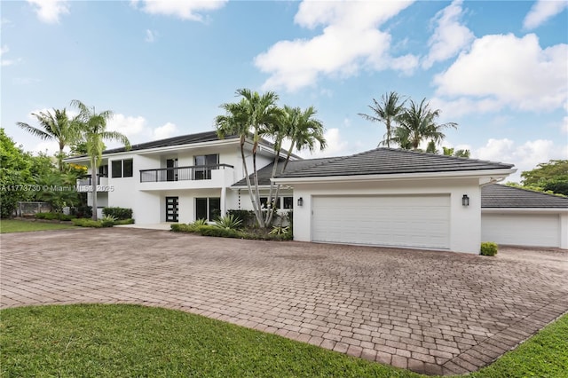 413 Santurce Ave, Coral Gables, FL 33143 - view of front facade with a balcony, stucco siding, decorative driveway, an attached garage, and a tiled roof