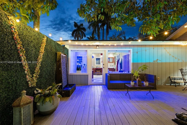 wooden terrace featuring outdoor lounge area and an outbuilding