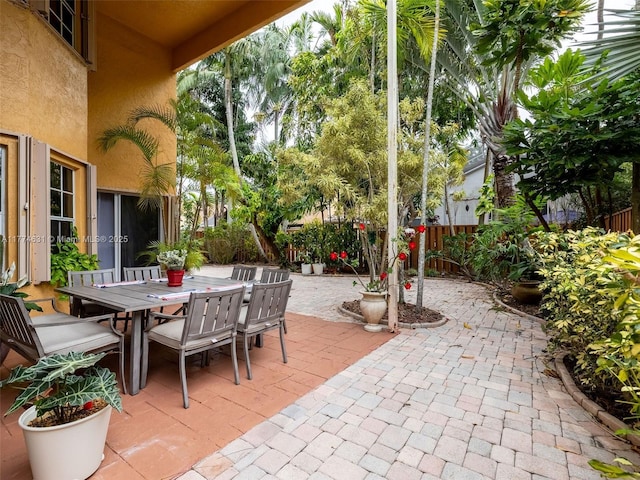 view of patio with outdoor dining space and fence