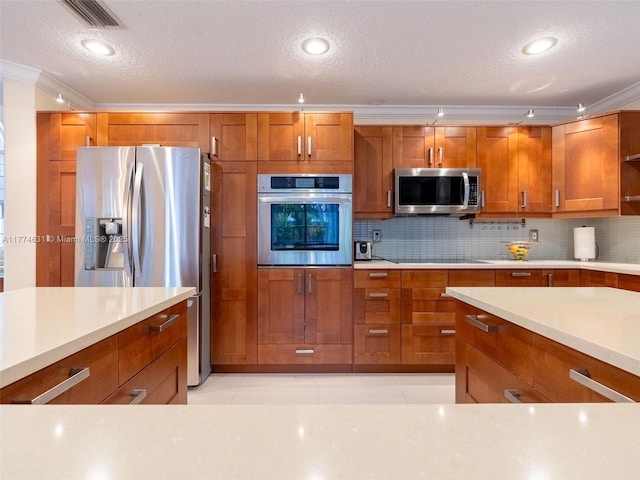 kitchen with light countertops, stainless steel appliances, and brown cabinets