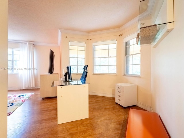 office area featuring light wood finished floors, baseboards, crown molding, and arched walkways