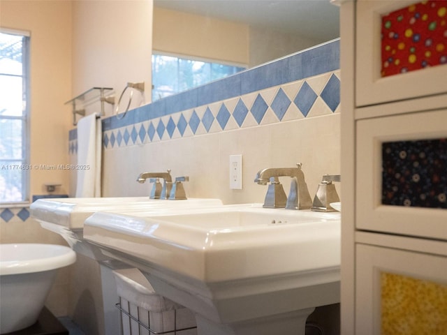 bathroom featuring tile walls, a wealth of natural light, and a sink
