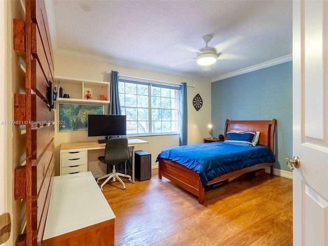 bedroom with light wood-type flooring, ornamental molding, and a textured ceiling