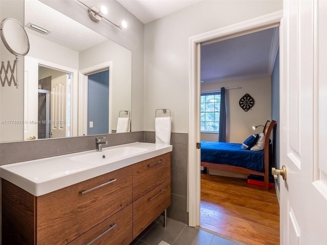 bathroom with vanity, tile walls, tile patterned floors, visible vents, and ensuite bathroom