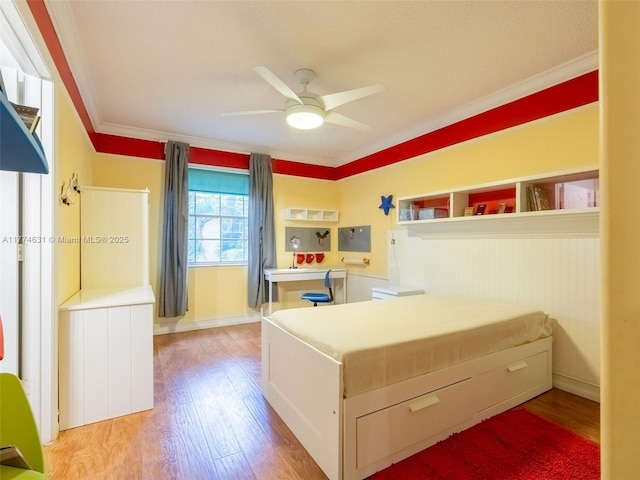 bedroom with ornamental molding, ceiling fan, and light wood-type flooring