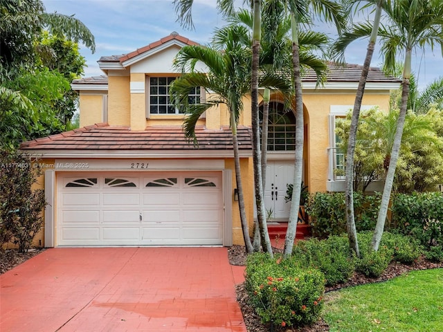 view of front of property with a tiled roof, decorative driveway, stucco siding, and an attached garage