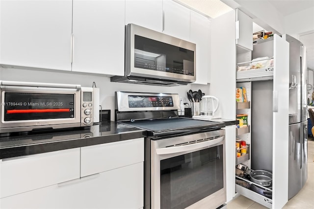 901 SW 141st Ave Unit 409M, Pembroke Pines, FL 33027 - kitchen featuring stainless steel appliances, white cabinets, dark countertops, and modern cabinets