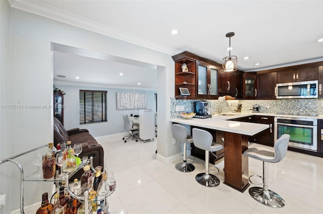 kitchen featuring a sink, ornamental molding, light countertops, appliances with stainless steel finishes, and decorative backsplash