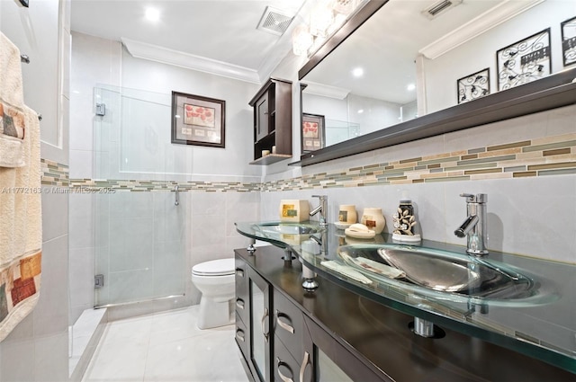 full bath with visible vents, a sink, tile walls, crown molding, and a shower stall