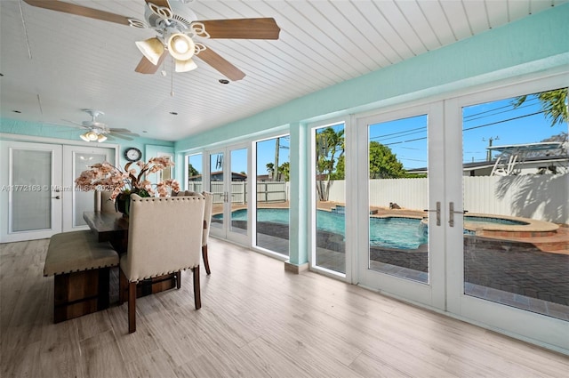 sunroom with plenty of natural light, french doors, and a hot tub