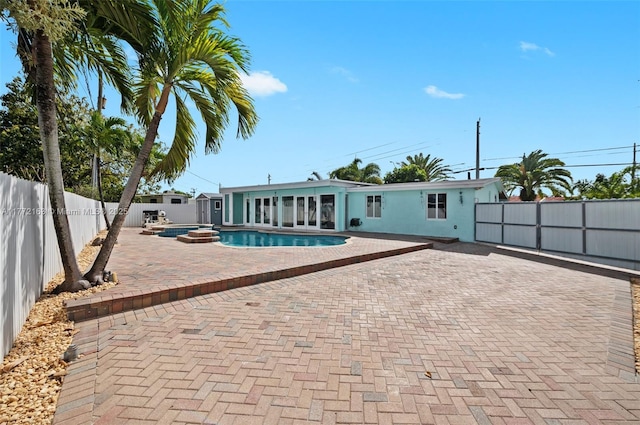 view of pool with a patio, a fenced backyard, a fenced in pool, and an in ground hot tub