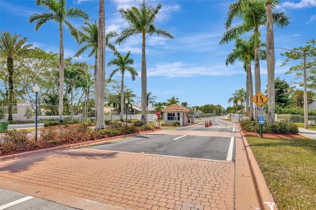 16249 NW 24th St, Pembroke Pines, FL 33028 - view of asphalt street featuring traffic signs, curbs, a gate, and a gated entry