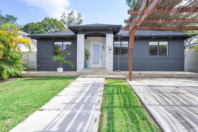 266 NE 117th St, Miami, FL 33161 - view of front of home with a shingled roof, a front lawn, and a pergola