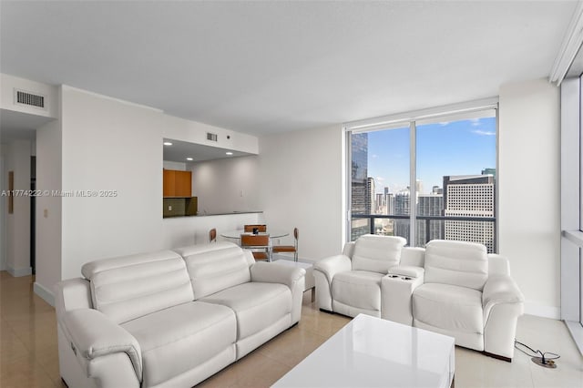 living room with light tile patterned flooring, baseboards, a view of city, and visible vents