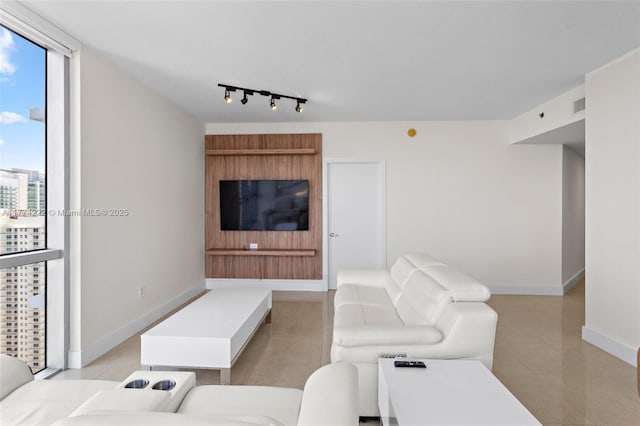 living room featuring rail lighting, light tile patterned flooring, baseboards, and visible vents