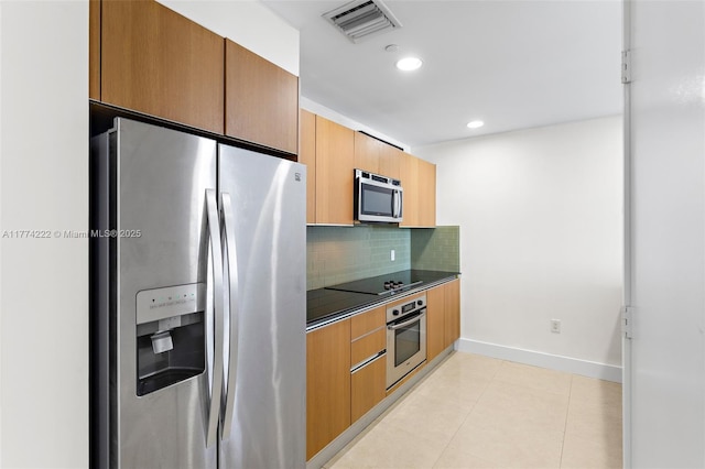 kitchen with backsplash, appliances with stainless steel finishes, dark countertops, light tile patterned floors, and visible vents