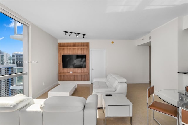 living area with baseboards, floor to ceiling windows, and track lighting